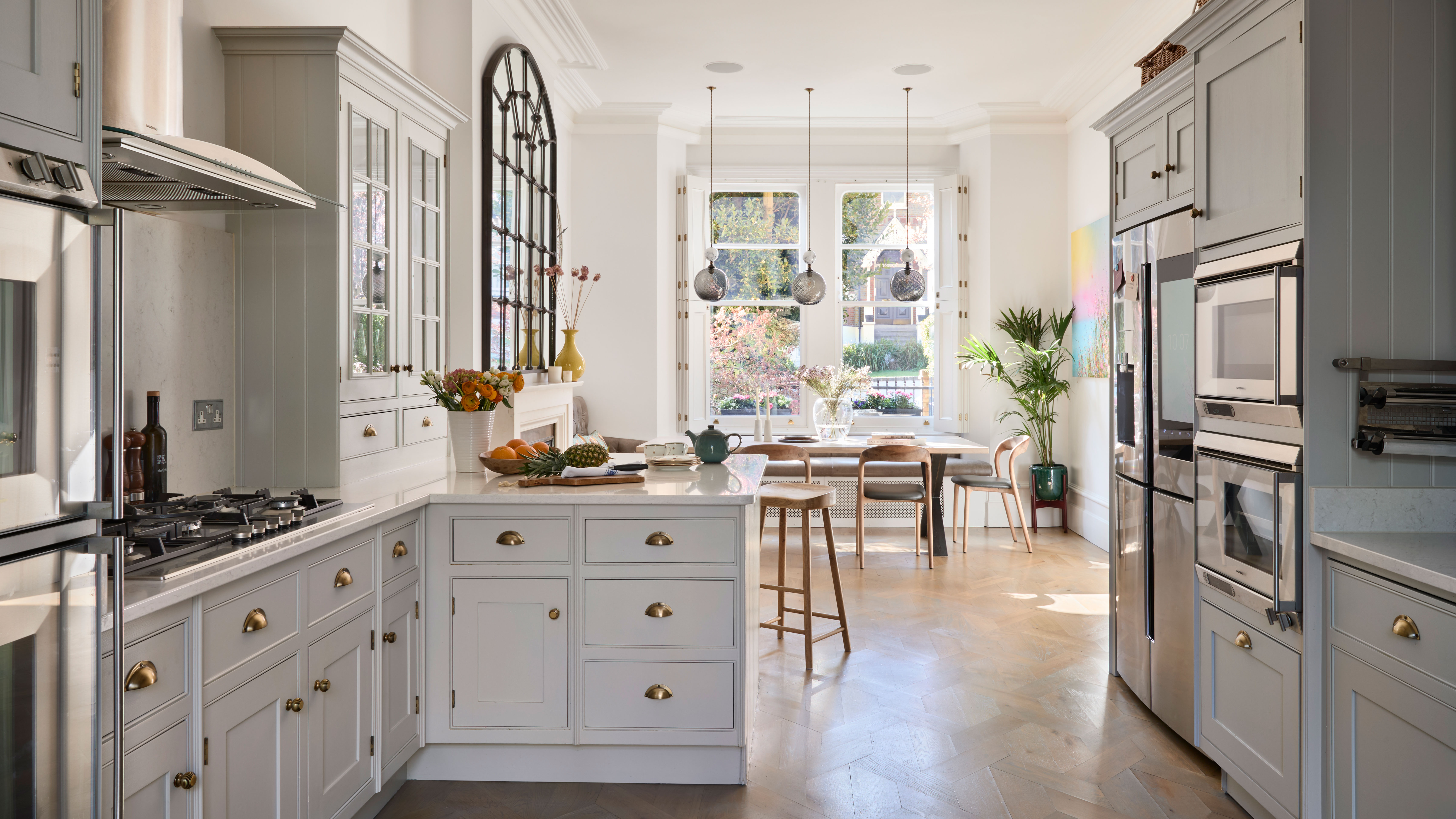 Elegant white kitchen with marble backsplash, gas cooktop, glass cabinets, and wood accents by California HarborCrest Kitchen Design